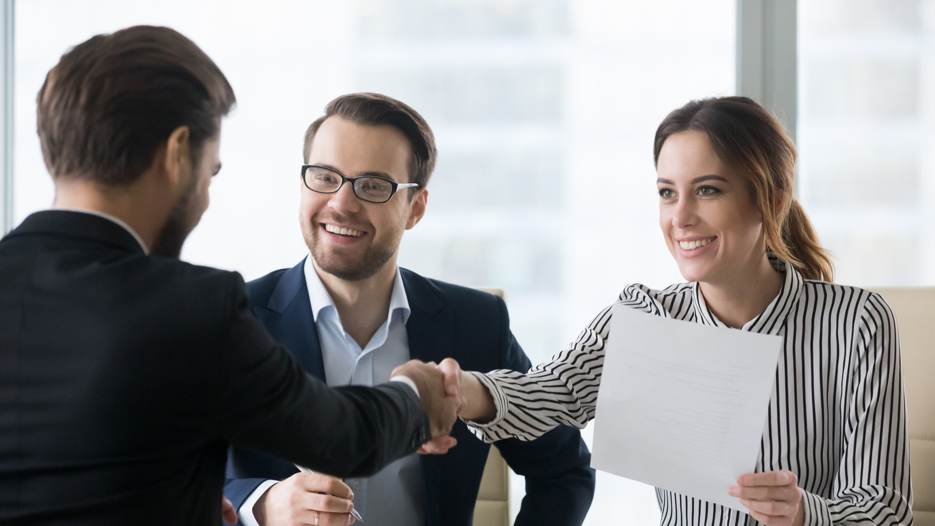  Photo of three people discussing at a conference table