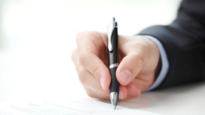 Close up image of a hand writing with a pen